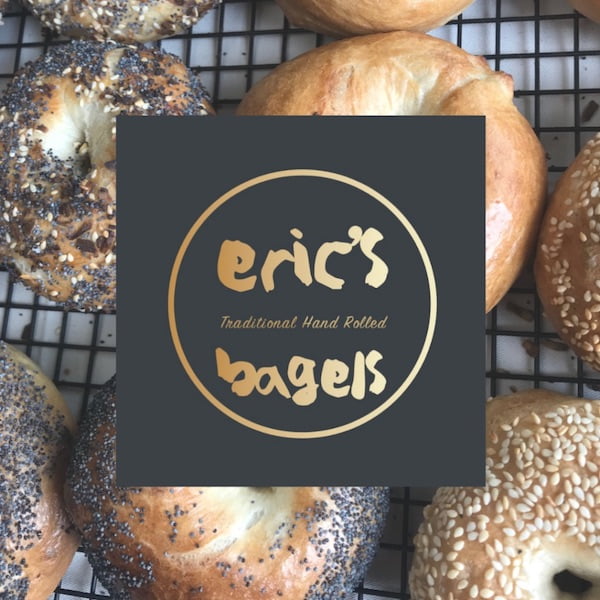 Logo for Eric's bagels with an oven rack full of bagels